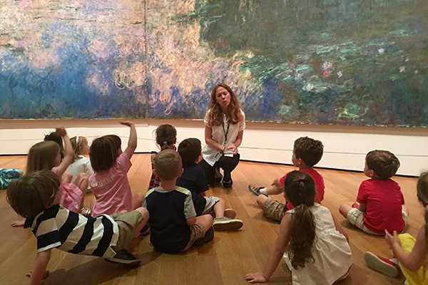 Teacher showing students art.